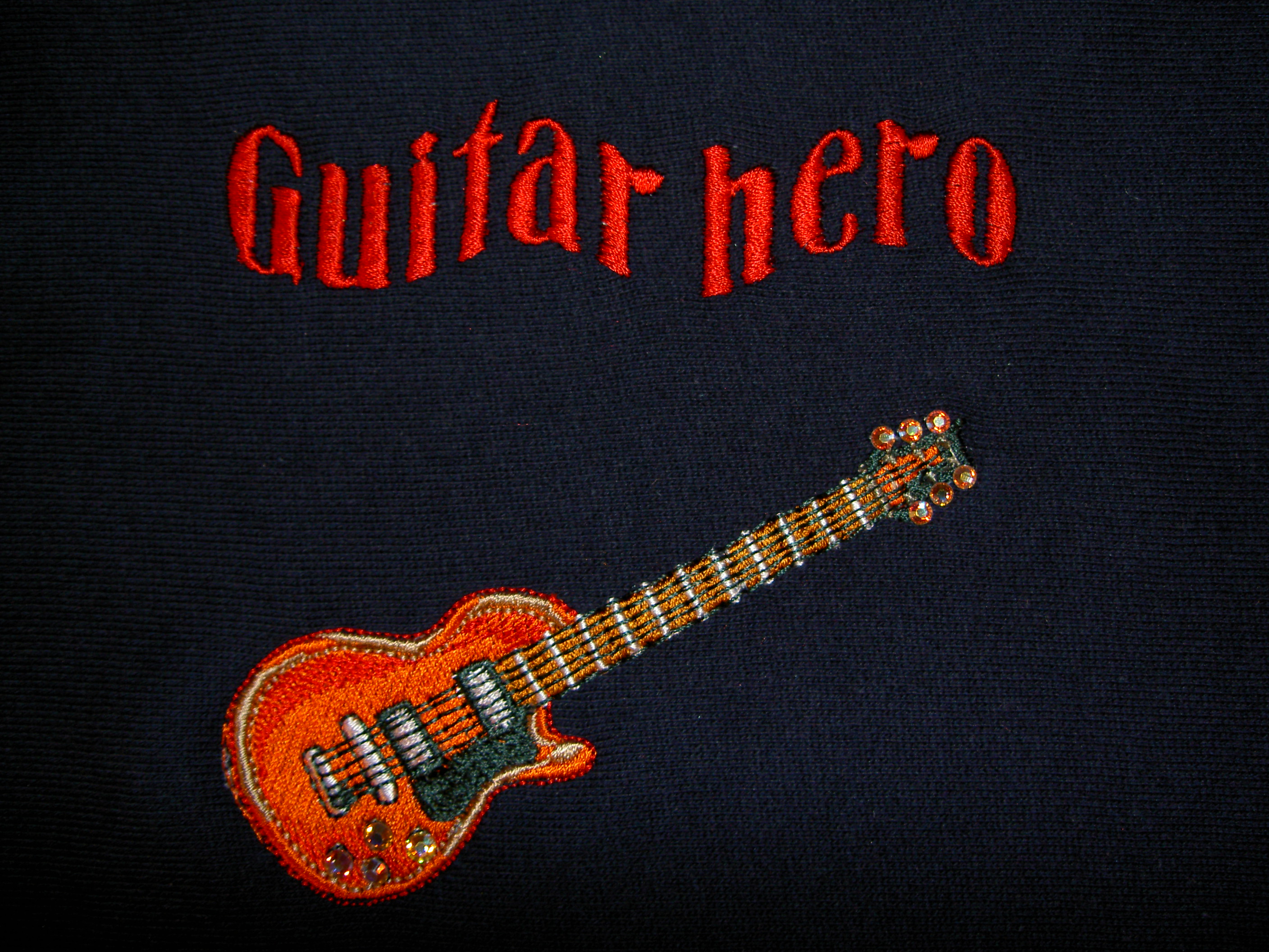 Broderad guitar med texten Guitar Hero